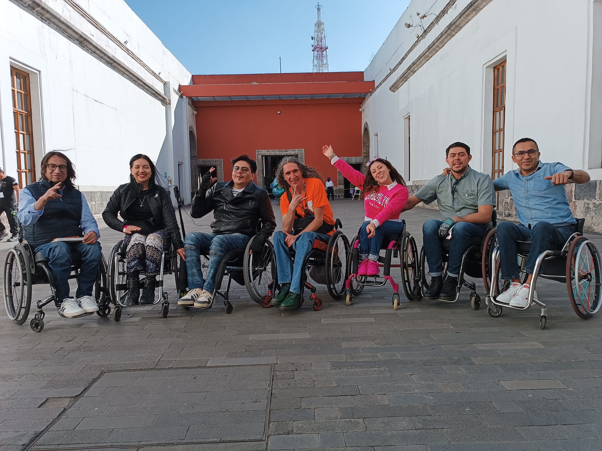 Conjunto de siete personas en silla de ruedas sonriendo mirando a la c?mara.