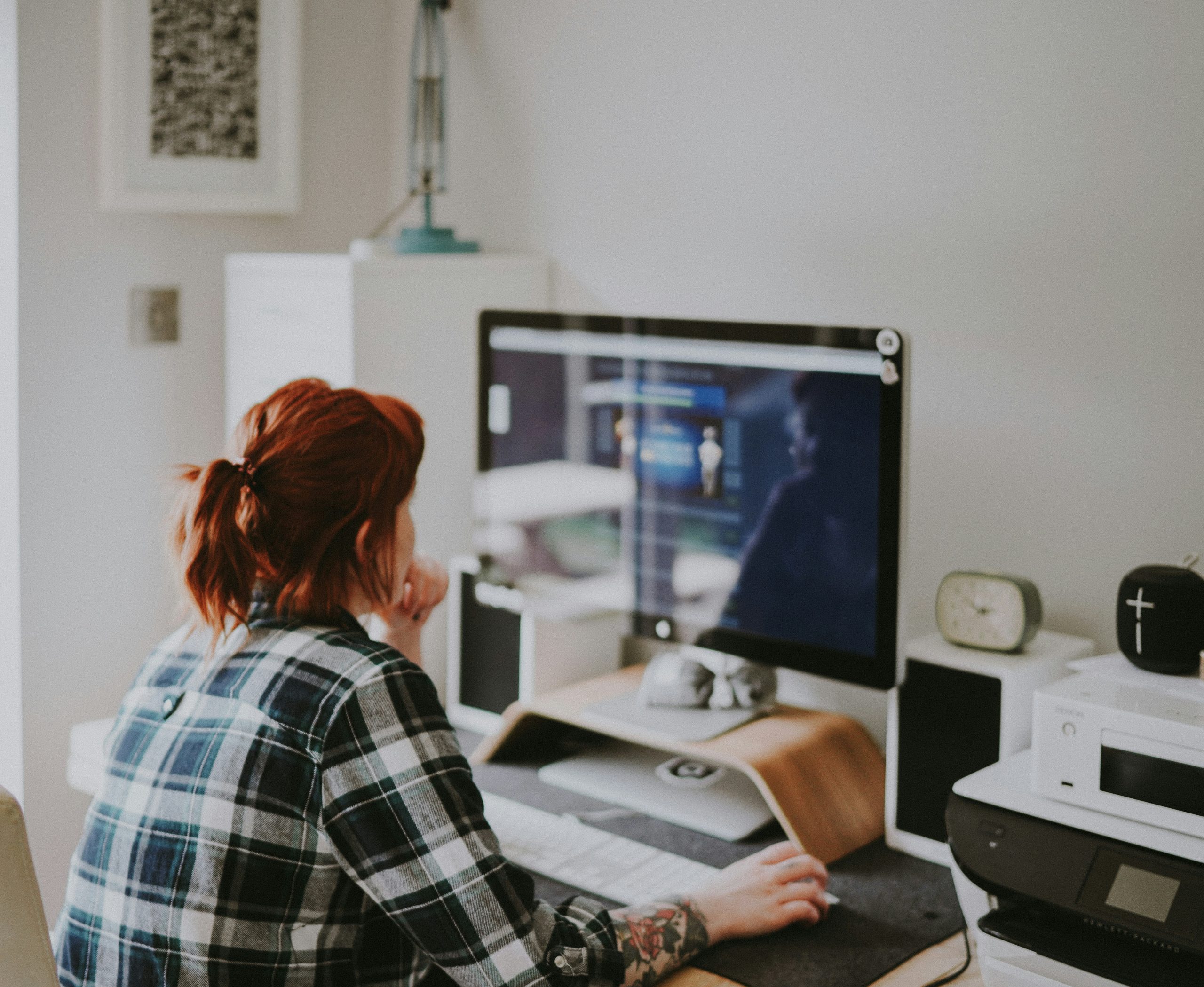 Mujer sentada frente a una computadora mientras trabaja.