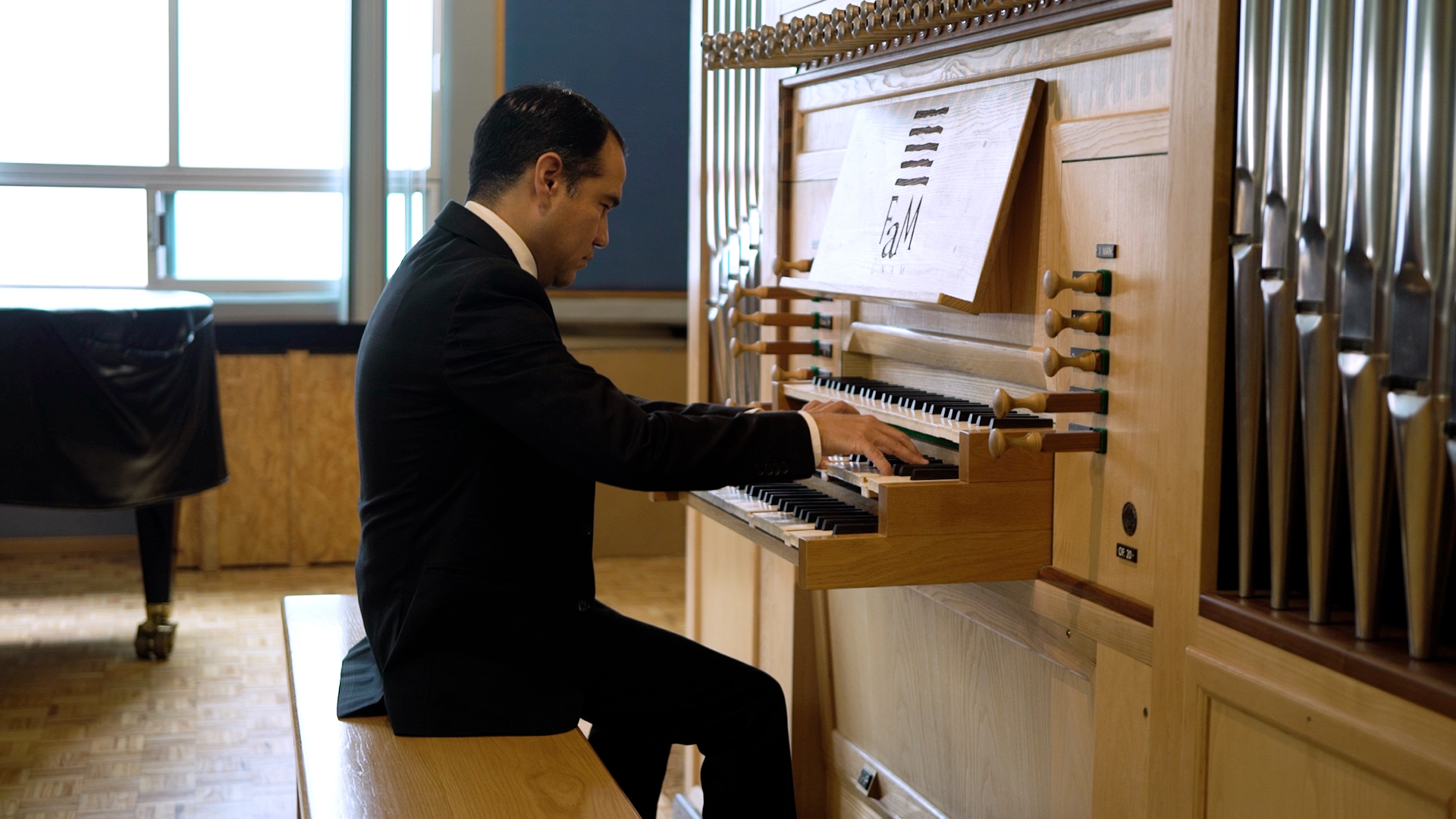 Carlos Iv?n Jacinto Sebasti?n tocando el ?rgano en solitario vestido con un traje